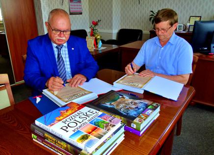  Najlepsi uczniowie wyróżnieni_fot_Wójt Adam Licznerski i przewodniczący Komisji Oświaty Adam Czarnecki podpisują pamiątkowe dyplomy dla uczniów